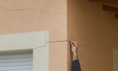 Un vecino muestra las grietas surgidas en su casa, que atribuye a las explosiones