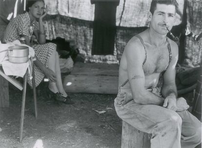 Um lenhador vai com sua mulher à colheita de feijões. Leva em seu braço tatuado o número de segurança social. Oregón, 1939