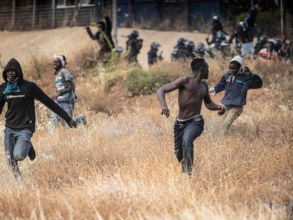 Varias personas migrantes corren en suelo español tras cruzar las vallas que separan Melilla de Marruecos el viernes 24 de junio de 2022.