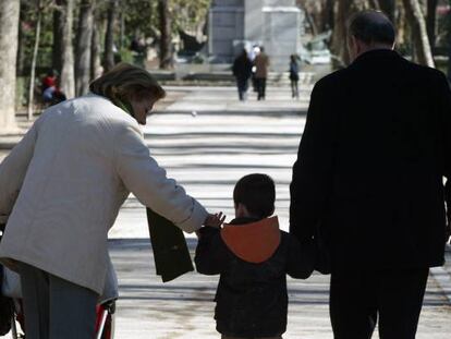 Una pareja pasea con su nieto en Madrid.