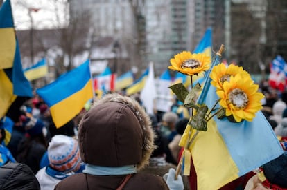 Una manifestante sostiene girasoles y una bandera ucrania mientras algunos ciudadanos de ese país protestan en Quebec (Canadá).