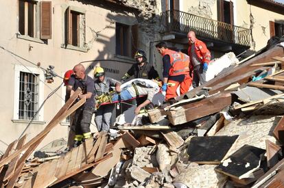 Los equipos de emergencia rescatan a un hombre que ha quedado atrapado entre los escombros causados por un terremoto en Arquata del Tronto (Italia).