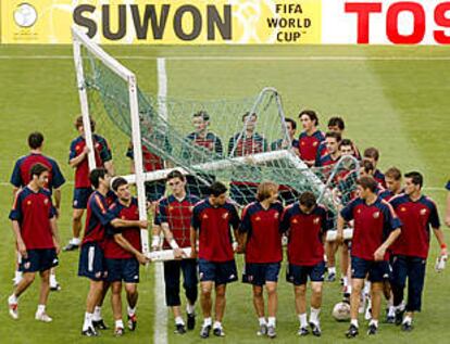 Los jugadores de la selección española, dirigidos por Raúl, colaboran en el traslado de una portería.