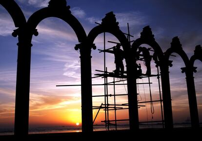 Operarios trabajan en la construcción de unos arcos en la playa de Clifton, en Karachi (Pakistán).