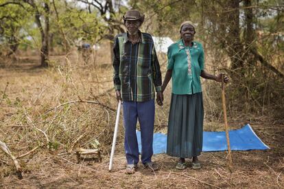 Alfred Wani y su esposa Kassa posan para una fotografía en el terreno que les ha asignado el Gobierno ugandés para su reasentamiento en el campo de Impevi. La pareja no alberga esperanza de volver a su hogar en Sudán del Sur.