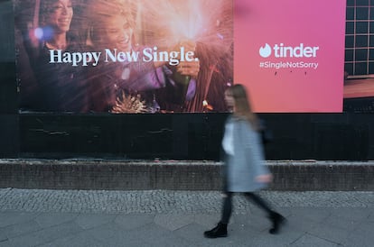 Una mujer pasa por delante de un anuncio de la aplicación de citas Tinder.