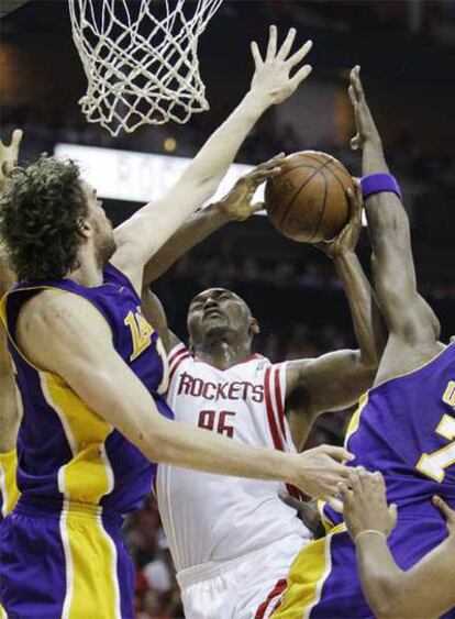 Artest trata de encestar entre Gasol y Odom.