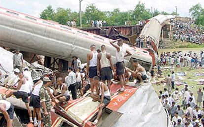 Los equipos de rescate buscan entre los escombros del tren que descarriló ayer al este de India. PLANO GENERAL - ESCENA