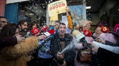 Varias personas celebran el Gordo del sorteo extraordinario de Navidad de la Lotería Nacional que ha recaído en el nº 88.008, este viernes en la Administración de la calle Monforte de Lemos de Madrid.