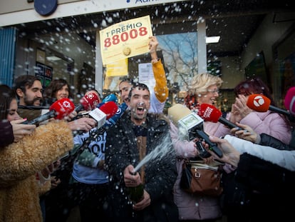 Varias personas celebran el Gordo del sorteo extraordinario de Navidad de la Lotería Nacional que ha recaído en el nº 88.008, este viernes en la Administración de la calle Monforte de Lemos de Madrid.