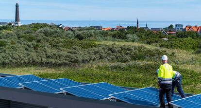 Dos obreros colocan paneles solares en el acuario de Borkum (Alemania).