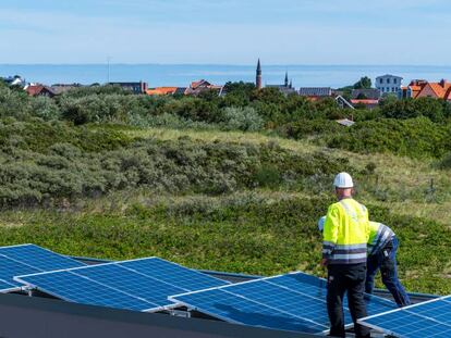 Dos obreros colocan paneles solares en el acuario de Borkum (Alemania).