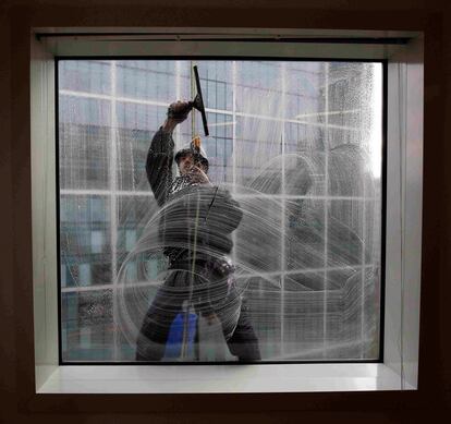 Un trabajador limpia las ventanas de un edificio del distrito financiero de Londres.