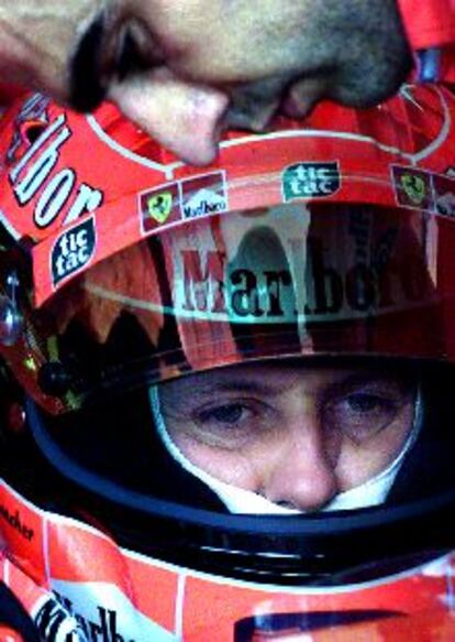 Un mecánico ajusta el Ferrari ante Michael Schumacher.