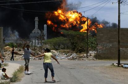 Vecinos de la barriada Alí Primera escapan de las llamas en la refinería de Amuay.