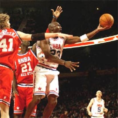 Jordan intenta una canasta presionado por Nowitzki, de los Dallas Mavericks y Garnett, de los Timberwolves.