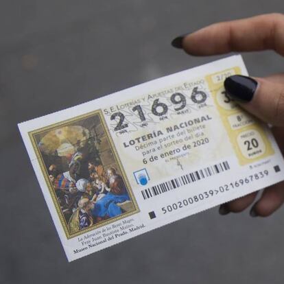 Una mujer muestra su numero de boleto de la lotería del Niño.