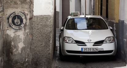 Un taxi avanza por la calle de San Juan de los Reyes, en el Albaic&iacute;n.