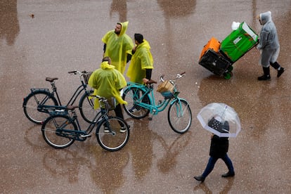 Varias personas se protegen de la lluvia en la ciudad de Valencia.