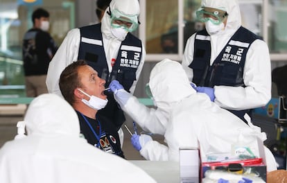 Varios sanitarios toman muestras para la prueba de coronavirus en el aeropuerto de Incheon, el pasado viernes.