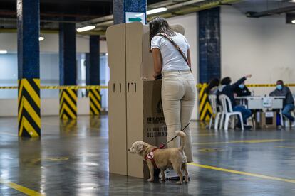 Una mujer vota en el parqueadero del edificio Murillo Toro en Bogotá.