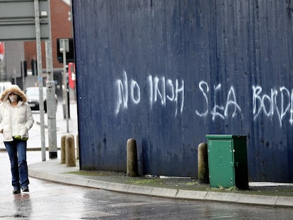 Una mujer camina el 3 de febrero a lado de una de las pintadas contra la frontera del mar de Irlanda, en Belfast.