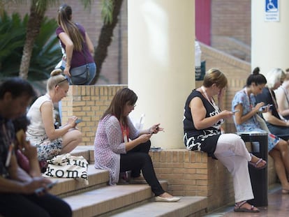 Participantes en un congreso en Sevilla consultan sus m&oacute;viles.