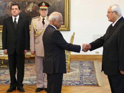 El presidente Mansur saluda al nuevo primer ministro, el economista Hazem el Beblaui durante el acto de investidura.