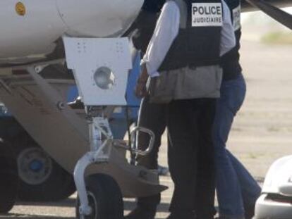 French police lead arrested ETA leader Mikel Carrera into an airplane in Biarritz.