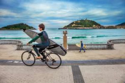 Un surfista en el paseo de la playa de la Concha (San Sebastián).