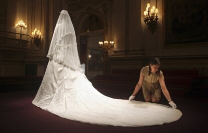 El palacio de Buckingham acogerá a partir de mañana una exposición con muchos de los objetos de la boda del príncipe Guillermo y su ya esposa, Catalina, que tuvo lugar el pasado 29 de abril en la abadía de Westminster. De todos ellos, la estrella es -sin duda- el vestido que lució Kate, diseñado por Sarah Burton, la actual directora creativa de la firma Alexander McQueen. En la imagen, la comisaria de la exposición, Caroline de Guitaut, realiza los últimos retoques al vestido.