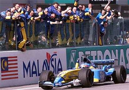 Fernando Alonso saluda a los miembros del equipo Renault tras cruzar tercero la línea de meta.