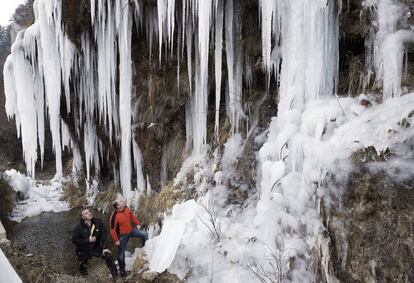 Dos personas observan carámbanos de hielo que debido a las bajas temperaturas se han formado junto a la carretera NA-137, en Navarra.