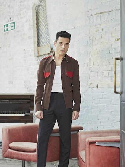 Rami Malek posa para ICON con la boca cerrada, chaqueta, camiseta y pantalones Calvin Klein 205w39nyc y botas Saint Laurent by Anthony Vaccarello.