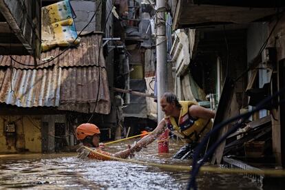 Al menos 26 personas han muerto en Indonesia debido a las inundaciones que han afectado a Yakarta y a la propia capital del país desde Nochevieja. En la imagen, un hombre es ayudado a salir de su casa en Yakarta, Indonesia.
