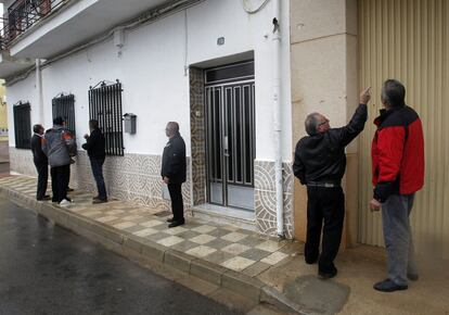 Desiderio (segundo por la derecha), hermano de una de las víctimas mortales (el hombre) muestra a un vecino los impactos de bala en el lugar donde falleció su hermano.