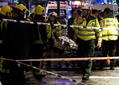 Una mujer tendida en una camilla rodeada del personal de emergencias atiende a la escena.