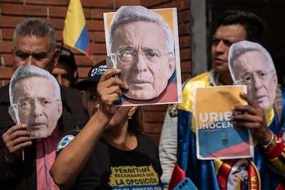 Manifestantes portan máscaras con el rostro del exmandatario colombiano a las afueras de los juzgados de Paloquemao.