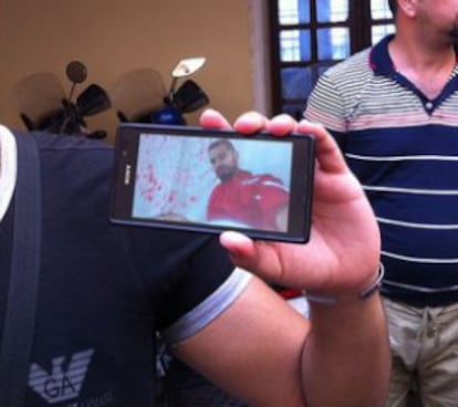 R.J. muestra una imagen en su móvil con el uniforme de la Media Luna Roja en Siria.