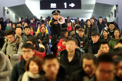 Un policía da indicaciones a los viajeros en la estación de tren de Yuncheng del Norte durante el comienzo del Festival de Primavera, en Yuncheng (China), el 1 de febrero de 2018.