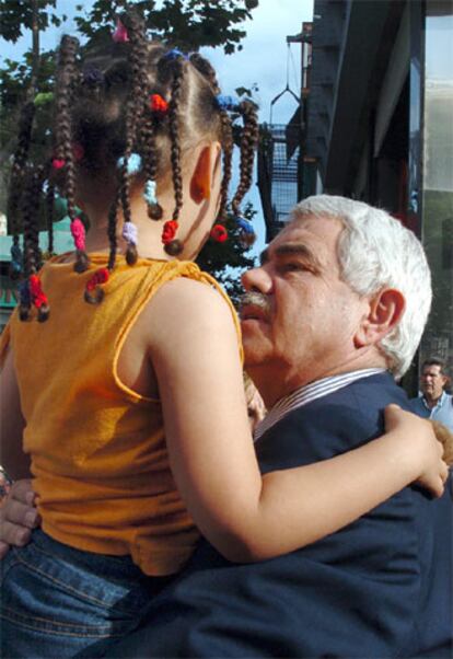 Maragall coge en brazos a una niña antes de un mitin a favor del Estatut en Hospitalet de Llobregat.
