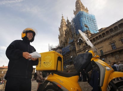 Un funcionario de Correos porta unos sobres con el voto por correo para la mesa instalada en el rectorado de la Universidad Compostelana, situada en la Plaza del Obradoiro.