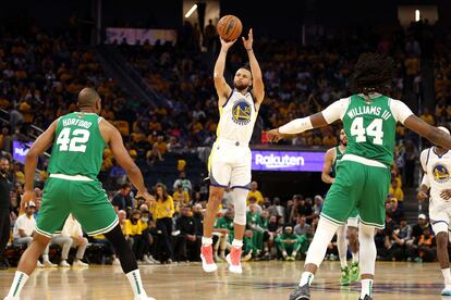 Stephen Curry lanza un triple ante la mirada de Al Holford (izquierda) y Robert Williams III de Boston Celtics.