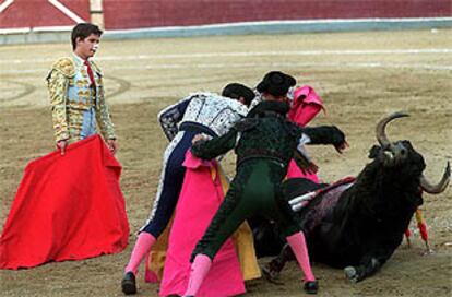El Juli observa a su cuadrilla, que intenta levantar al tercer toro en una de sus numerosas caídas.