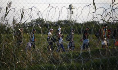 Migrantes a pie pasan detrs de la valla despus de que agentes de la polica hngara cerraran la frontera entre Serbia y Hungra en R?szke, el sur de Hungra.