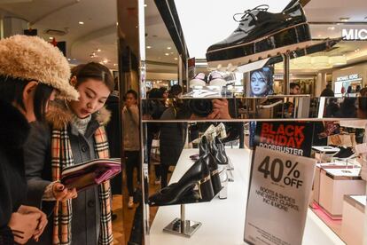 Unas jóvenes observan unos zapatos en la sección de zapatería de la tienda Macy's de Nueva York (Estados Unidos).