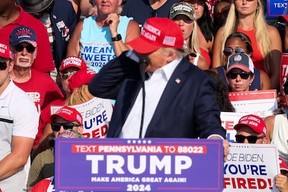 El candidato presidencial republicano Donald Trump reacciona cuando se escuchan múltiples disparos y siente el golpe en su oído derecho, durante un mitin de campaña en el Butler Farm, (Pensilvania),  el 13 de julio de 2024. 