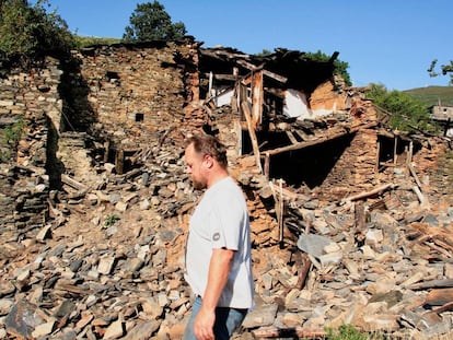 Martin Verfondern, en septiembre de 2009, pasa ante una de las ruinas que siembran el pueblo de Santoalla do Monte.