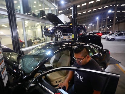 Un trabajador de la ‘startup’ de compra y venta de autos mexicana Kavak inspecciona una unidad, en 2020.