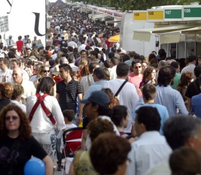 Ambiente en la Feria del Libro en el parque del Retiro de Madrid con multitud de personas entre las casetas.